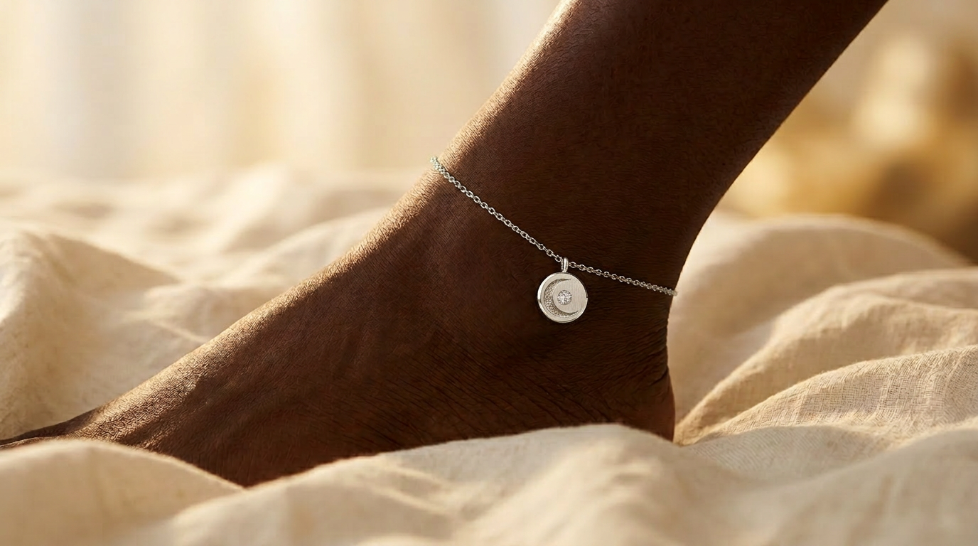 Lunar Anklet on a Black woman's ankle in golden hour light, delicate 14K white gold cable chain with miniature medallion