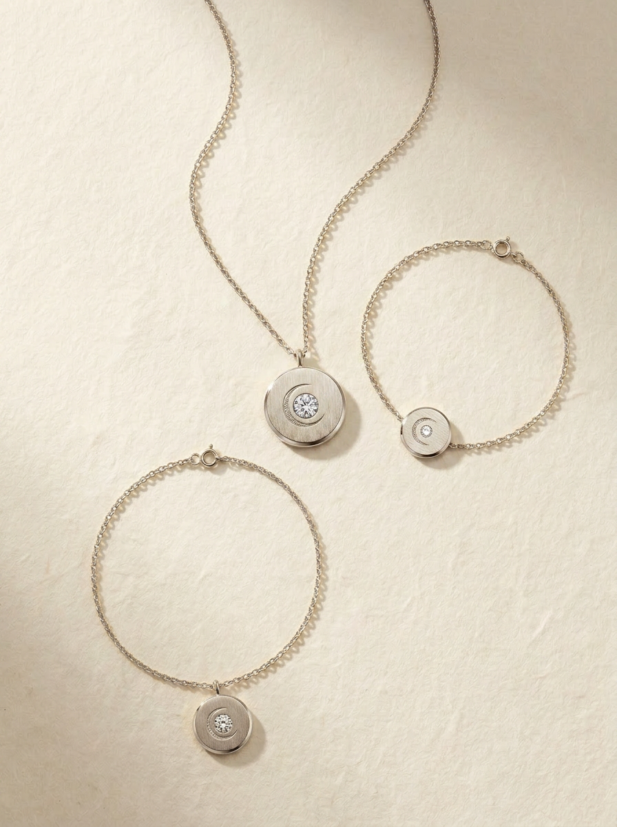 The Lunar Set in solid 14K white gold — necklace, bracelet, and anklet with the brushed Lunar Medallion charm and round brilliant lab-grown diamond
